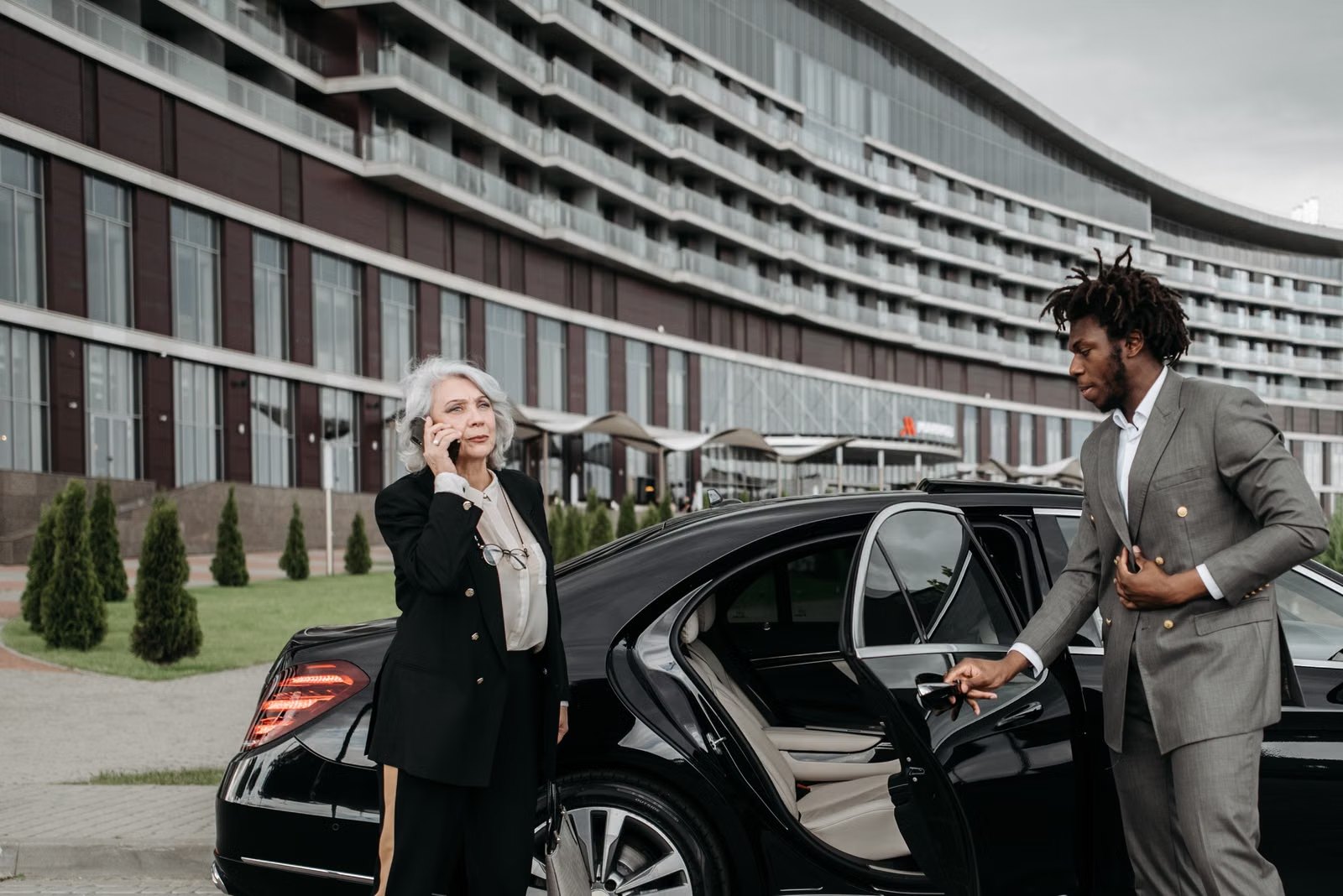Chauffeur opening car door for business guest